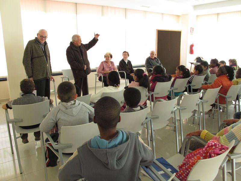al portal de casa i els constructors. Jordi Canudas - ACVic Visita als avis del Club Sant Jordi del barri del Remei. Els nens els pregunten com era abans el barri.